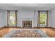 Bright living room with hardwood floors, a decorative fireplace, large windows, and an oriental rug at 4807 Graceland Ave, Indianapolis, IN 46208