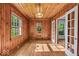 Wood paneled sun room with hardwood floors, and many windows with transoms at 4807 Graceland Ave, Indianapolis, IN 46208