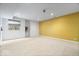 Spacious basement with bright yellow accent wall, carpet, and natural light at 8418 Mesic Ct, Indianapolis, IN 46278