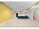 Finished basement with carpet, yellow accent wall, and a blue sofa at 8418 Mesic Ct, Indianapolis, IN 46278