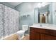 Bathroom features a floral shower curtain, white fixtures, and single sink at 8418 Mesic Ct, Indianapolis, IN 46278