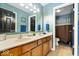 Bathroom featuring double sinks, wood cabinets, and a blue accent wall at 8418 Mesic Ct, Indianapolis, IN 46278