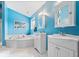 Bright blue bathroom with a soaking tub, double sinks, and updated cabinetry at 8418 Mesic Ct, Indianapolis, IN 46278