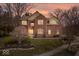 Charming red brick two-story home with a well-manicured lawn and mature trees at 8418 Mesic Ct, Indianapolis, IN 46278