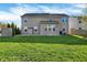 Backyard of home featuring large green lawn, neutral vinyl siding, and concrete patio at 612 Reunion Ln, Greenwood, IN 46143
