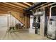Unfinished basement area showcases exposed stairs and a combination furnace and water heater at 612 Reunion Ln, Greenwood, IN 46143