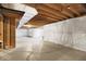 Unfinished basement features exposed beams and plastic-covered walls for potential customization at 612 Reunion Ln, Greenwood, IN 46143
