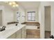 Bathroom with double sinks, large mirror, soaking tub and tiled surround at 612 Reunion Ln, Greenwood, IN 46143