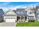Charming two-story home boasts a well-manicured lawn, attached two car garage and inviting front porch at 612 Reunion Ln, Greenwood, IN 46143