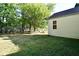 Spacious backyard with mature trees and the home's exterior with window at 850 S Holmes Ave, Indianapolis, IN 46221