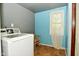 Laundry room with a white washing machine, blue walls, and a window for natural light at 850 S Holmes Ave, Indianapolis, IN 46221
