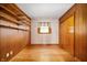 Bedroom featuring wood floors, a window, a closet, and wood-paneled walls, blending style and functionality at 1504 N Knightstown Rd, Shelbyville, IN 46176