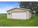 Exterior shot of detached garage with a large white door and siding at 1504 N Knightstown Rd, Shelbyville, IN 46176