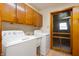 Bright laundry room features cabinets, modern washer and dryer units, and convenient utility sink at 1504 N Knightstown Rd, Shelbyville, IN 46176