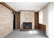 Living room showcasing a stone fireplace, neutral carpet, and wooden wall paneling, creating a cozy space at 1504 N Knightstown Rd, Shelbyville, IN 46176