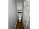 Small half-bathroom with a toilet, dark shelving, and wood-style flooring at 2307 Blackthorn Dr, Franklin, IN 46131