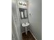 Cozy powder room featuring a pedestal sink, decorative mirror, and neutral color palette at 2307 Blackthorn Dr, Franklin, IN 46131