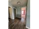 Hallway with hardwood flooring, open doorways, and a glimpse into a bedroom with pink walls at 2307 Blackthorn Dr, Franklin, IN 46131