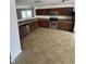 A kitchen with stainless steel appliances, tiled flooring, and dark brown cabinets at 2307 Blackthorn Dr, Franklin, IN 46131