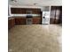 A kitchen with stainless steel appliances, tiled flooring, and dark brown cabinets and pantry at 2307 Blackthorn Dr, Franklin, IN 46131