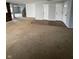 An open-concept living room features bright carpet and transitions to the stairs to the basement at 2307 Blackthorn Dr, Franklin, IN 46131