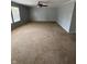 Carpeted living room featuring a ceiling fan, neutral tones, and natural light streaming through the window at 2307 Blackthorn Dr, Franklin, IN 46131