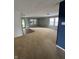 A large living room with neutral paint and carpet has multiple bright windows at 2307 Blackthorn Dr, Franklin, IN 46131