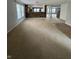 An open-concept living room features bright carpet and transitions to the stairs to the basement at 2307 Blackthorn Dr, Franklin, IN 46131