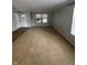A large living room with neutral paint and carpet has both a front and side door at 2307 Blackthorn Dr, Franklin, IN 46131