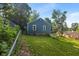 Backyard view of blue home with green grass, fence, and landscaping at 327 Central Ave, Anderson, IN 46012
