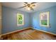 Bedroom with wood floors, ceiling fan, and natural light from two windows at 327 Central Ave, Anderson, IN 46012