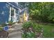 Charming blue home showcasing a stone accent, flower boxes on the porch and a landscaped garden at 327 Central Ave, Anderson, IN 46012