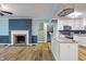 Open-concept living room and kitchen featuring light-colored walls, a fireplace, and light-colored cabinets at 327 Central Ave, Anderson, IN 46012