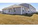 View of gray-sided home with multiple windows and an outdoor seating area on a green lawn at 6286 Wasco Dr, Whitestown, IN 46075