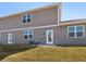 A view of the home's gray exterior with a door leading to the backyard and large windows for natural light at 6286 Wasco Dr, Whitestown, IN 46075