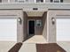 Welcoming entrance between townhome garages, featuring covered porch and exterior lighting at 6286 Wasco Dr, Whitestown, IN 46075