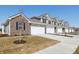 Long view of townhomes with garages, grassy lawns and landscaping at 6286 Wasco Dr, Whitestown, IN 46075