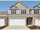 Charming townhome featuring a two-car garage, neutral siding, and classic black shutters at 6286 Wasco Dr, Whitestown, IN 46075