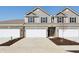 Townhome showcasing neutral siding, a two-car garage, and tasteful front yard landscaping at 6286 Wasco Dr, Whitestown, IN 46075