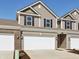 View of townhome showing a two-car garage, neutral siding, and simple landscaping at 6286 Wasco Dr, Whitestown, IN 46075