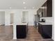 Modern open kitchen featuring a white island, dark cabinetry, stainless steel appliances and hardwood floors at 6286 Wasco Dr, Whitestown, IN 46075