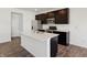 Modern kitchen features stainless steel appliances, dark cabinetry, and a large island with a white countertop at 6286 Wasco Dr, Whitestown, IN 46075