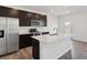 Modern kitchen with stainless steel appliances, dark cabinets, hardwood floors, and a white center island at 6286 Wasco Dr, Whitestown, IN 46075
