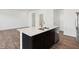 Kitchen island features dark cabinetry, a white countertop, double sink, and stainless steel dishwasher at 6286 Wasco Dr, Whitestown, IN 46075