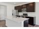 Modern kitchen features stainless steel appliances, dark cabinetry, and a large island with a white countertop at 6286 Wasco Dr, Whitestown, IN 46075