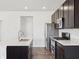 Modern open kitchen with a white island, dark cabinets, stainless steel appliances, and hardwood flooring at 6286 Wasco Dr, Whitestown, IN 46075