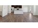 Modern open kitchen with white island, dark cabinets, stainless steel appliances and hardwood floors at 6286 Wasco Dr, Whitestown, IN 46075