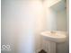 Bathroom features a pedestal sink and decorative mirror at 6296 Wasco Dr, Whitestown, IN 46075