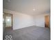 A large bedroom has neutral carpet, a window and two entry doors at 6296 Wasco Dr, Whitestown, IN 46075
