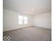 A big bedroom has a large window and neutral carpet, and an entry door at 6296 Wasco Dr, Whitestown, IN 46075